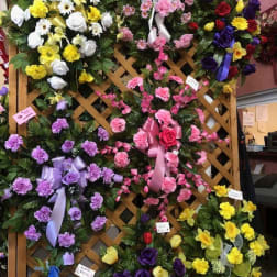 Assorted floral wreaths and sprays on a lattice display