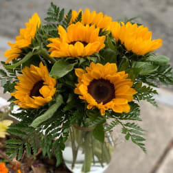 Bouquet of yellow sunflowers in a clear glass vase