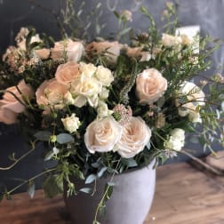 Blush and white roses arranged in a gray vase