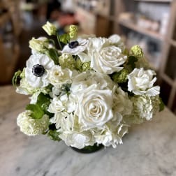 White roses and anemones in a compact bouquet