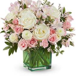 Pink and white roses with alstroemeria in a green glass vase