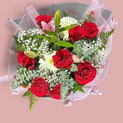Bouquet of red roses and white flowers wrapped in pink paper