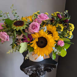 Bouquet of sunflowers and pink roses in a white vase