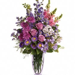 Purple and pink mixed bouquet in a clear glass vase