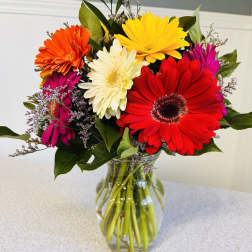 Colorful gerbera daisy bouquet in a clear glass vase