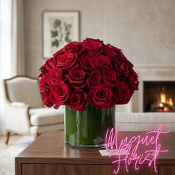 Red rose bouquet in a clear glass vase on a table