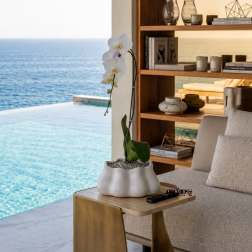White orchid in a white ceramic pot on a side table by the sea.