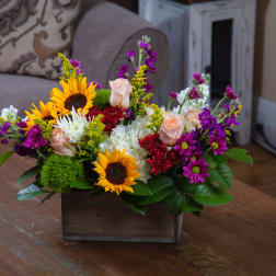 Mixed bouquet with sunflowers, roses, and chrysanthemums in a wooden box