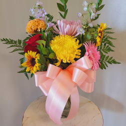 Mixed bouquet of bright flowers tied with a pink ribbon