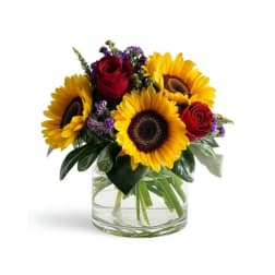 Sunflowers and red roses in a clear glass vase