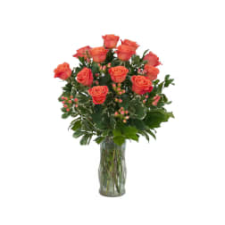 Orange roses arranged in a clear glass vase