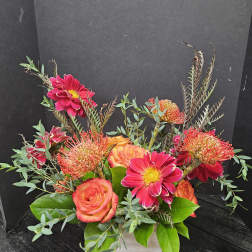 Bright pink and orange flowers arranged in a white wooden box