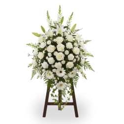 White floral standing spray on a wooden easel