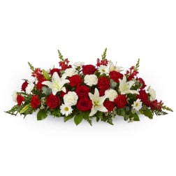 Low floral arrangement with red roses, white lilies, and white daisies