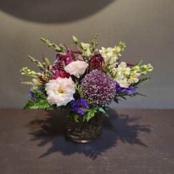 Mixed bouquet in a glass vase with purple, white, and pink flowers