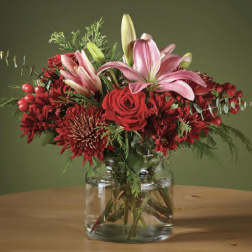 Red and pink floral arrangement in a clear glass vase