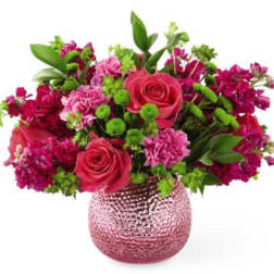 Pink and magenta flower arrangement in a textured glass vase