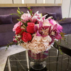 Pink and red floral arrangement in a glass vase