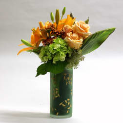 Orange lilies and peach roses arranged in a green vase