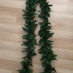 Two dark green leaf garlands laid on a wooden floor