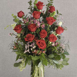 Tall bouquet of red roses in a clear glass vase