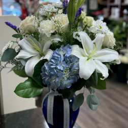 White lilies and blue hydrangea in a blue vase