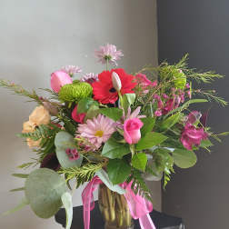 Mixed pink and red bouquet in a glass vase with ribbon
