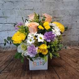 Mixed bouquet in a white cube vase with a "New Baby" decoration