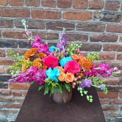 Colorful mixed flower arrangement in a ribbed glass vase