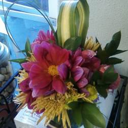 Bouquet of pink and yellow flowers with looping green leaves