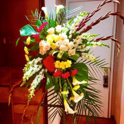 Large standing floral spray with white lilies, roses, and red accents