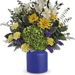 Bouquet of white, yellow, and purple flowers in a blue vase