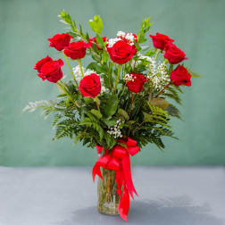 Red roses in a glass vase with a red ribbon