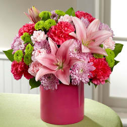 Pink lilies and mixed pink flowers in a magenta vase