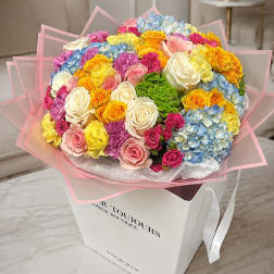 Large bouquet of multicolored roses and hydrangeas in a white gift box