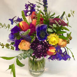 Colorful mixed bouquet in a clear glass jar vase