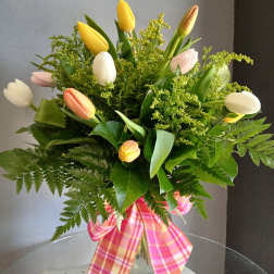 Mixed tulip bouquet in a glass vase with a pink plaid ribbon
