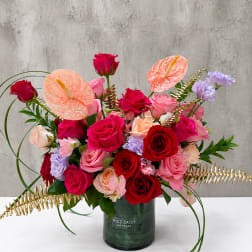 Mixed roses and anthuriums in a green vase