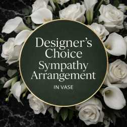 White roses and calla lilies arranged around a sympathy sign