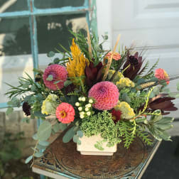 Mixed bouquet in a white square vase with pink and coral blooms