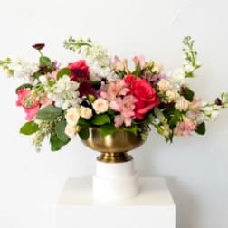 Mixed pink and white flower arrangement in a gold bowl vase