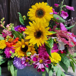 Mixed bouquet with sunflowers and colorful blooms in a metal container