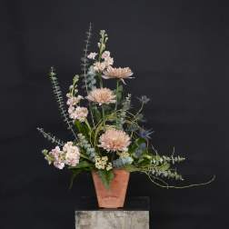 Tall pastel floral arrangement in a terracotta vase