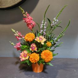 Orange and pink mixed flower arrangement in a copper vase
