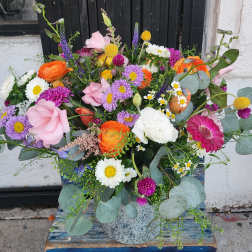 Colorful mixed bouquet in a speckled ceramic vase