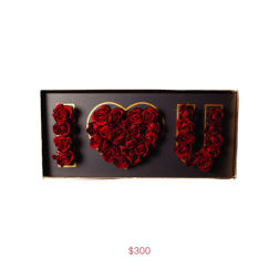 Red roses arranged to spell "I LOVE U" in a gift box