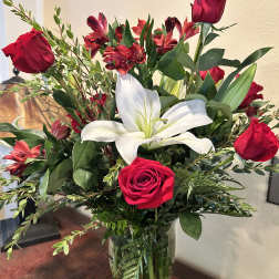 Bouquet of red roses and white lilies in a glass vase