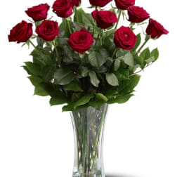 Tall arrangement of red roses in a clear glass vase