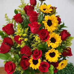 Bouquet of red roses and yellow sunflowers in a woven basket