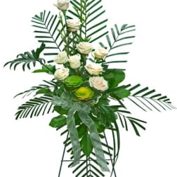 Standing floral spray with white roses and palm fronds on a tripod easel